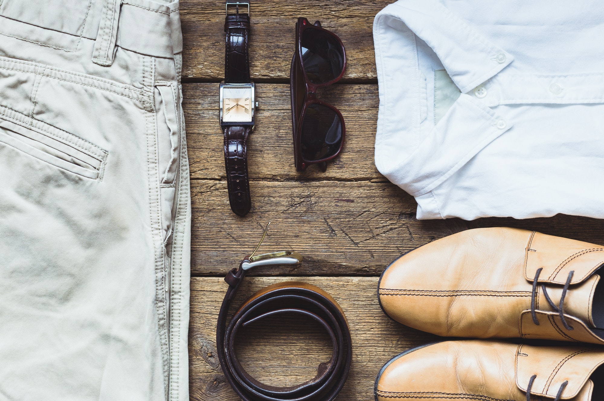 Men's clothes and accessories on wooden background. Top view